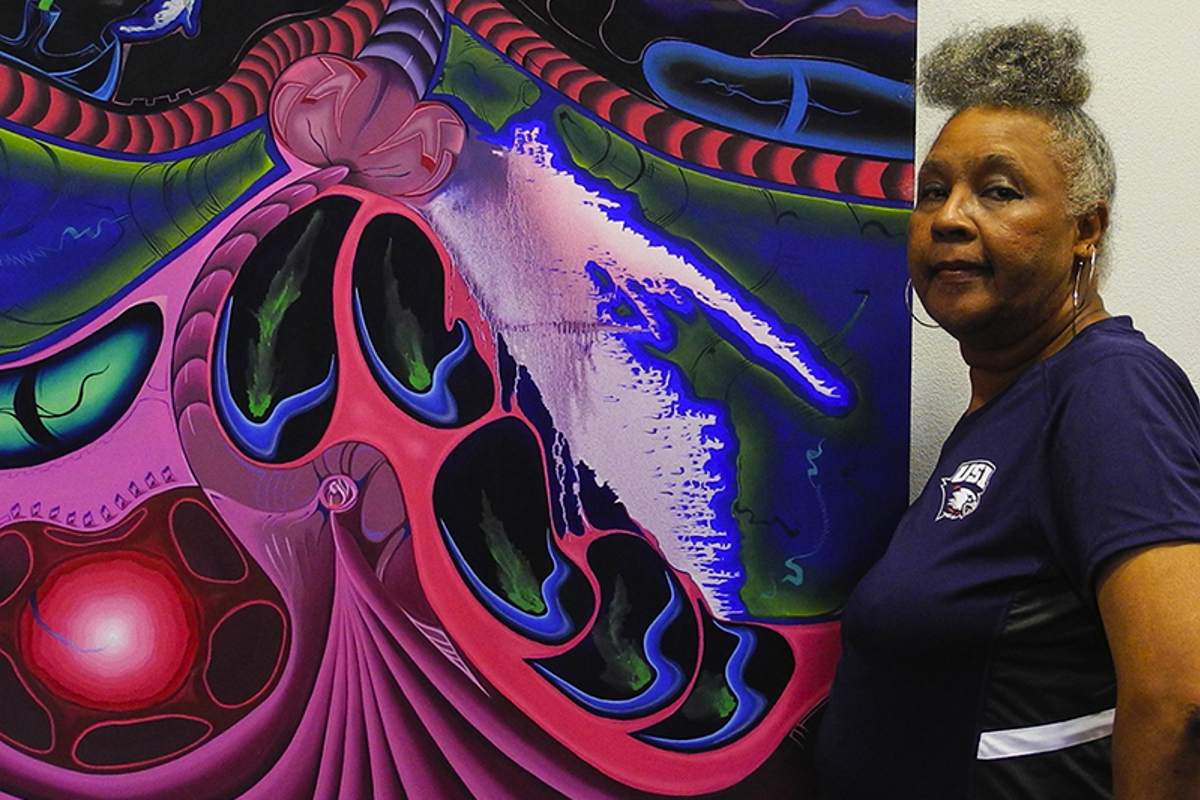 Virginia Thomas poses with painting by art alum, Kyle Fitzgerald.
