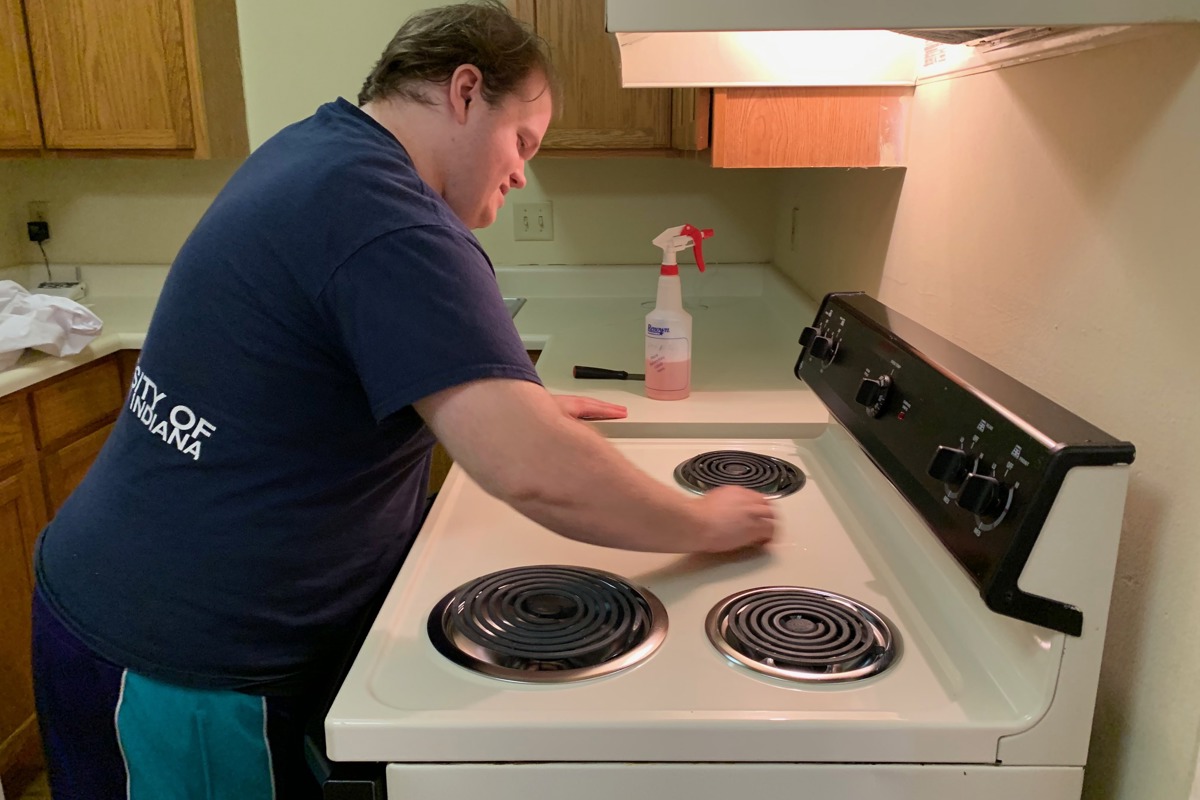 A USI student cleans a stove as part of Summer Rehab