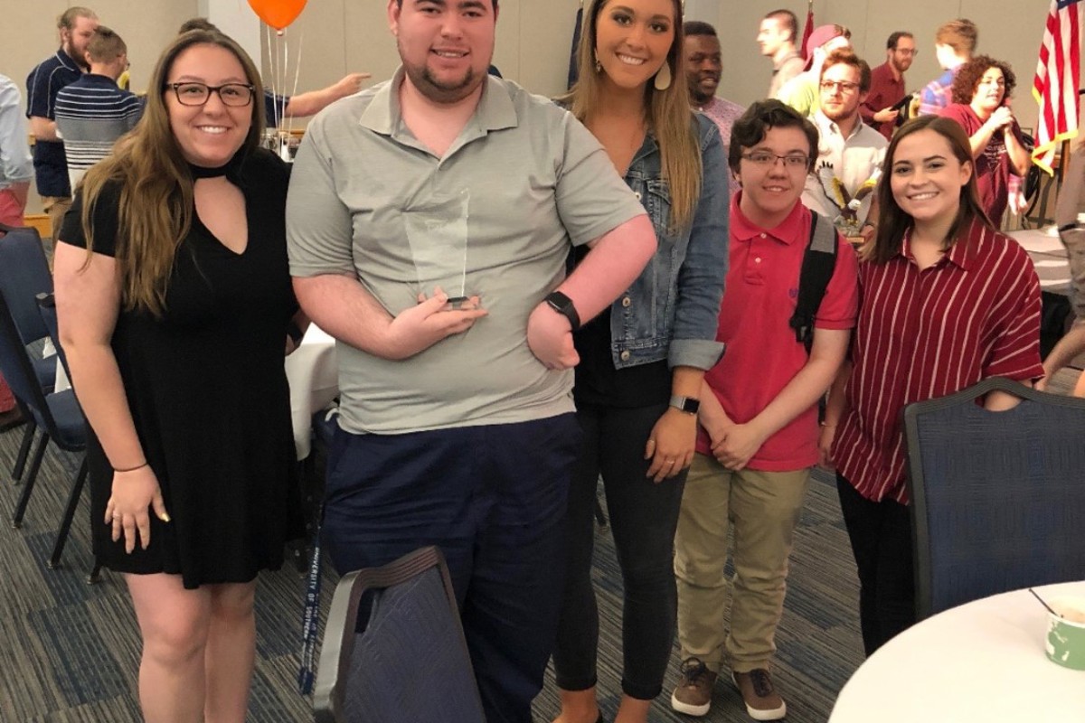 Elijah Laine '21, communication studies, displays the New Student Organization of the Year award that his organization, Disability Coalition, won at USI's 2019 Student Organization Celebration. 