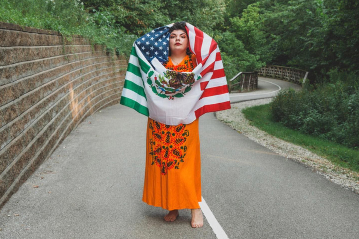 Kassandra Santos showcases her Chicana identity as she holds a flag representing the United States and Mexico.