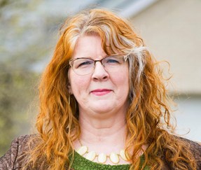 Amie Whittemore standing by a pond in the woods