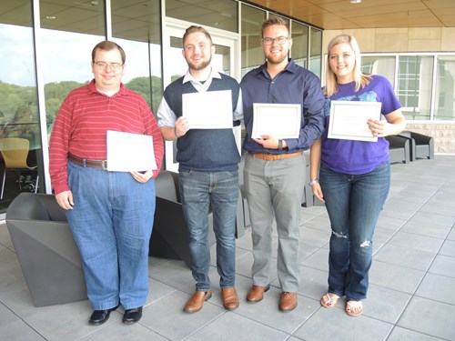 Four students holding their certificates