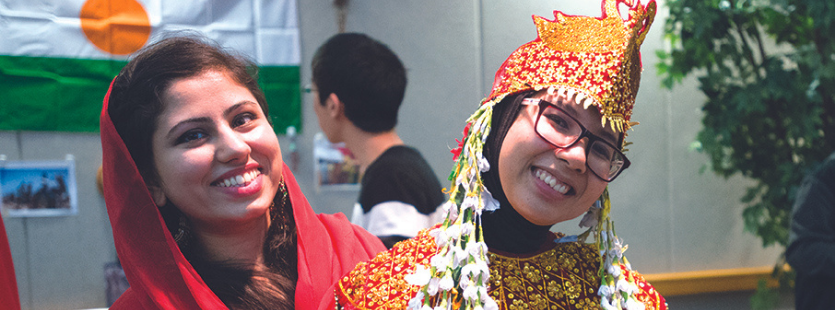 Two USI students in World Languages and Cultures wearing colorful outfits with head coverings
